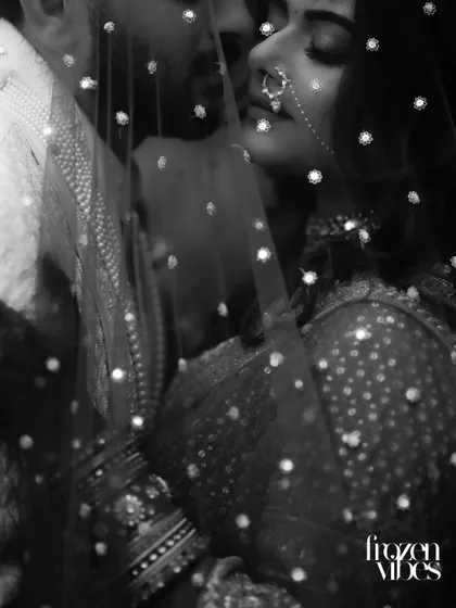 A moment of quiet intimacy between Nimit and Himani, captured in timeless black and white. The delicate veil adds a layer of artistry, focusing purely on the emotion and connection shared between them.