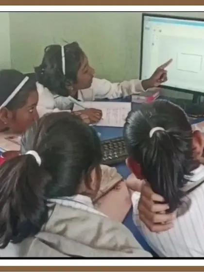 Collaboration is key to solving complex problems. Here, a group of students works together at a computer, pointing to the screen as they debug their code and figure out the logic for their project.