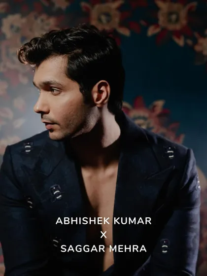 A profile shot of Abhishek Kumar, highlighting the sharp tailoring and the intricate pattern of the suit fabric. The mood is one of quiet confidence and modern elegance.