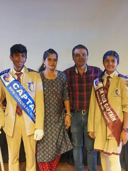 The new Captain and Vice-Captain of a school house pose with their proud parents, ready to take on their leadership responsibilities.