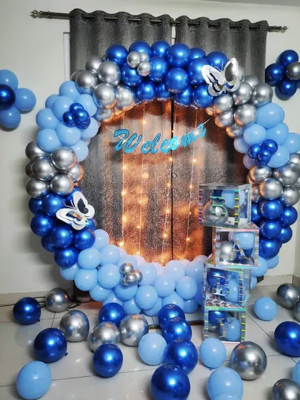 A beautiful welcome party decoration for a baby boy. This full balloon ring in shades of blue and silver chrome creates a stunning photo backdrop.