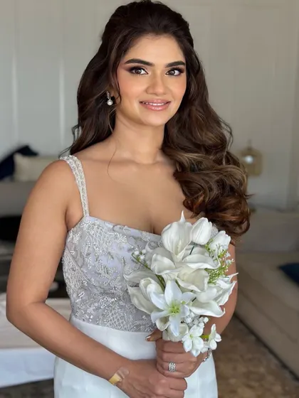 A beautiful bride ready for her white wedding or reception. Her look is soft and glamorous, with voluminous waves and a radiant smile.