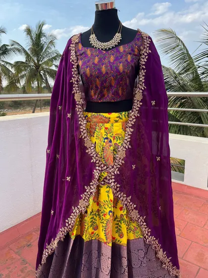 A traditional Langa Davani with a yellow Kalamkari skirt and a purple brocade blouse and dupatta.