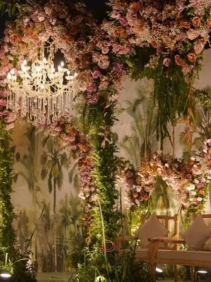 The elegant seating placed before the romantic floral arch backdrop, ready for the couple to make their appearance.