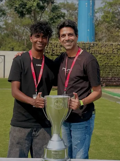 Our coach with the Reliance Foundation U15 girls championship trophy, showcasing our success at the youth level.