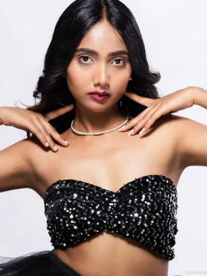 A close-up of the model in a sequined top, with a confident expression.