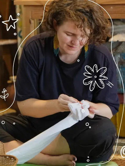 A participant sits cross-legged, deeply focused on tying her fabric. Our Shibori workshops are a chance to slow down, connect with an ancient craft, and enjoy a mindful, creative process.