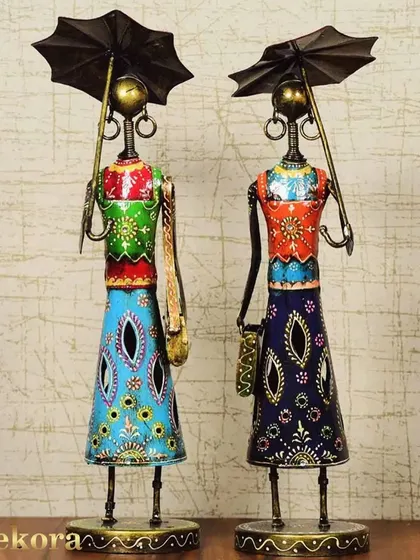 A set of two handcrafted metal figurines depicting ladies in traditional attire holding umbrellas. The vibrant, hand-painted details make these a unique and colorful addition to your home decor, celebrating Indian artistry.