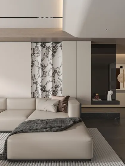 This living room showcases a subtle, luxurious aesthetic with a cream leather sofa and a striking book-matched marble panel. A built-in niche with curated objects adds a personal touch, while the overall design remains clean and uncluttered.