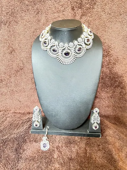 A simple yet elegant CZ stone choker set with purple stones. This rental includes a necklace, matching earrings, and a maang tikka.
