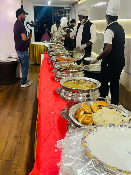 A professional buffet line being filmed at an event. Our team is always ready, wearing chef hats and uniforms, to provide top-notch service that looks as good as the food tastes.