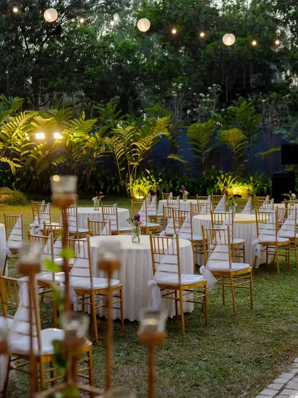 The outdoor seating for the Sangeet is arranged beautifully, with glowing lights and elegant table settings creating a magical atmosphere.