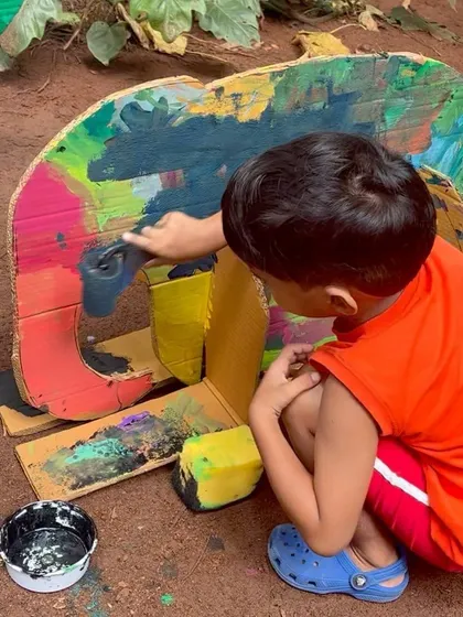 A child fully absorbed in painting a colorful cardboard elephant. Our sessions provide the space for kids to focus and bring their creative visions to life.