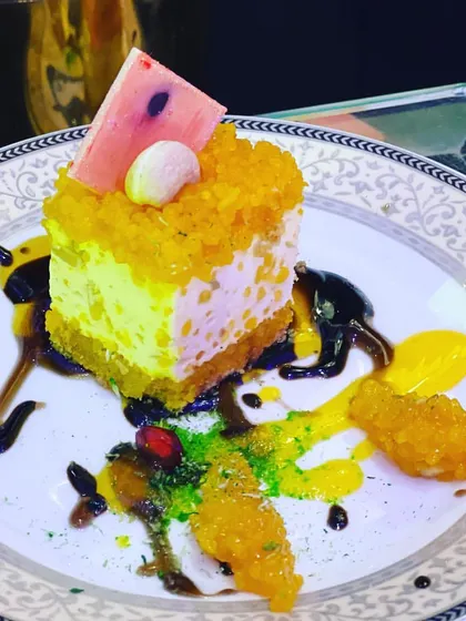 Every meal should end on a high note with an artistic dessert. This is a slice of my fusion cheesecake, beautifully plated with fruit coulis and motichoor crumble, demonstrating how I blend traditional flavors with contemporary presentation for a memorable finish.
