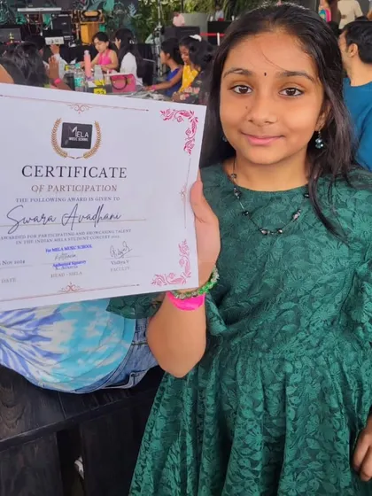 Another young performer holds her certificate after our concert. These moments of recognition are crucial for building the confidence of our little rockstars.
