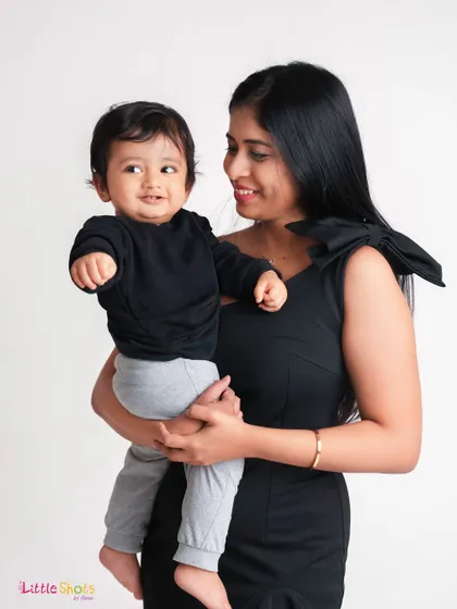 A mother's loving gaze at her baby boy. This simple, elegant portrait in matching black outfits beautifully captures the deep connection between them.