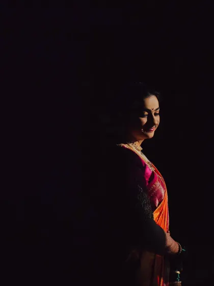 A dramatic portrait of the bride, with light just catching her face in the darkness.
