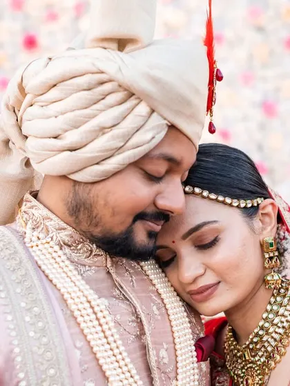 An intimate and emotional close-up. The bride resting her head on the groom's chest is a simple but powerful expression of love and trust.