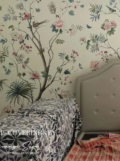 A bedroom wall becomes a canvas for a custom Chinoiserie mural. The artful placement of flowering trees and birds creates a tranquil and opulent atmosphere, setting the stage for true relaxation.