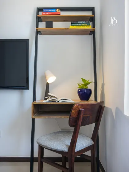 A closer look at the ladder desk, showing its simple, clean lines and how it provides just enough space for a laptop and a few books, making it an ideal work-from-home spot.