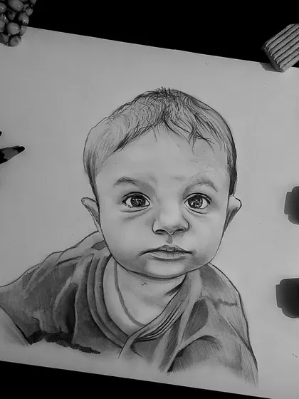 This A4 size baby portrait was created using graphite pencils. The image shows the finished sketch alongside the tools I use, giving a glimpse into my workspace.