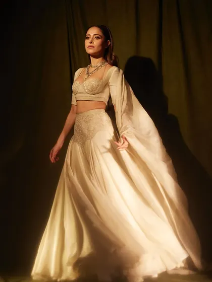 Less color, more depth. This ivory lehenga-style ensemble on Nushrratt is all about texture and silhouette, creating a dramatic and elegant look.