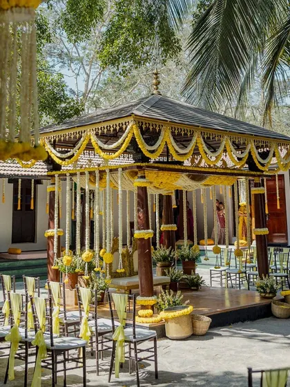 Another angle of the yellow-themed Haldi mandap, showing the guest seating with matching chair ties. This demonstrates the attention to detail in creating a fully coordinated event design.