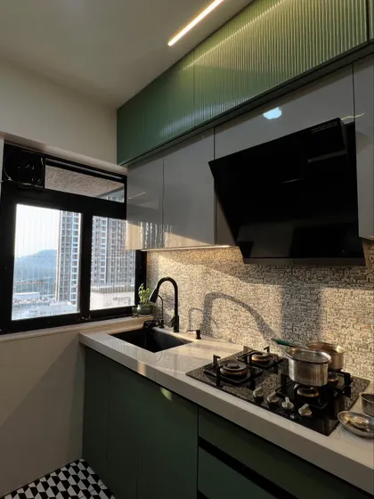 Sunlight streams into this kitchen, highlighting the beautiful mosaic backsplash, modern black fixtures, and sleek chimney.