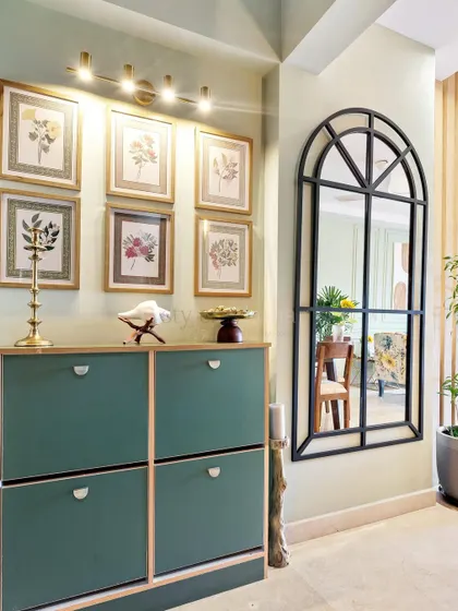 Foyers are the unsung heroes of the home. Here, a stylish green shoe cabinet and a large arched mirror provide both organization and a great first impression.