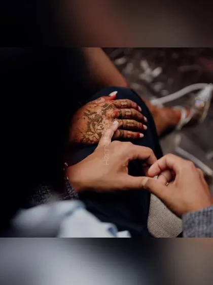 A sweet, candid moment captured during the mehendi application.