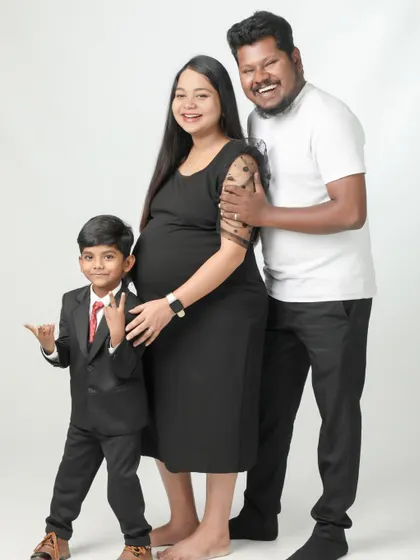 A happy family of three, soon to be four. The older brother is dressed in a smart suit and looks so excited to welcome his new sibling. A truly joyful family portrait.