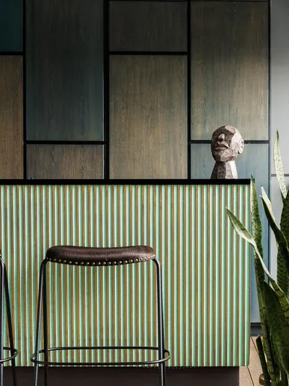 This bespoke outdoor bar is a seamless blend of craftsmanship and design. We paired a fluted mint-green facade with the richness of stained teak wood and matte black accents for a striking and artful look.