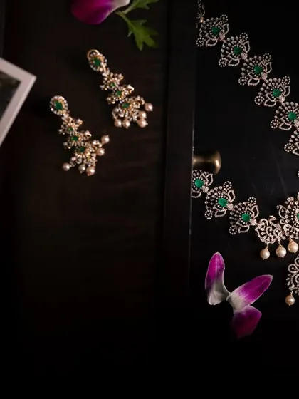 A dark and moody shot of a beautiful silver and emerald necklace set, capturing its elegance and craftsmanship.
