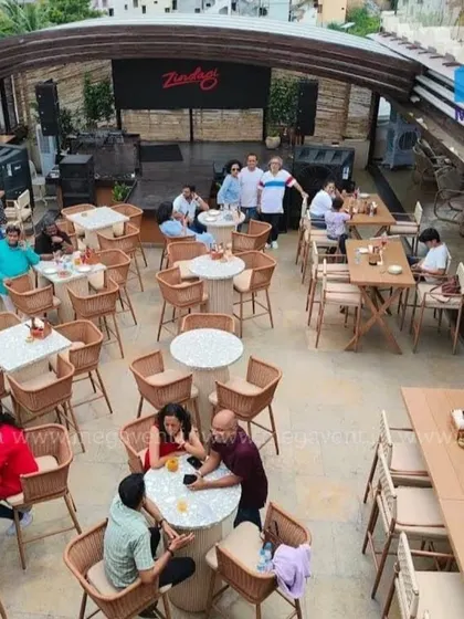 An aerial view of a rooftop restaurant setup, showcasing our durable and stylish cafe chairs and tables. Our retractable roof ensures business can continue, rain or shine.