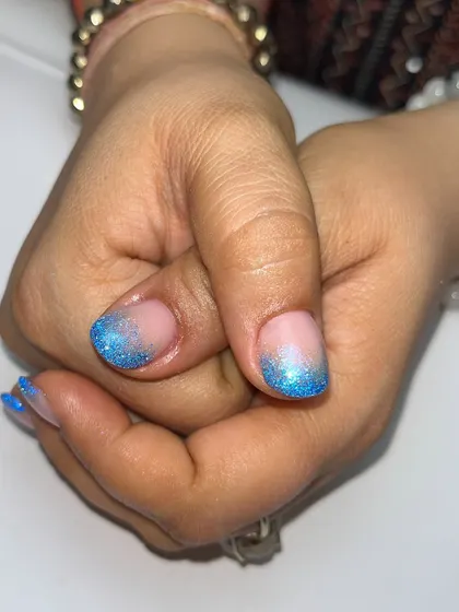 Another look at the dreamy blue glitter nails, showing how the sparkle fades into a soft, natural base.
