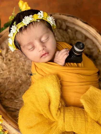 A future photographer in the making. This little one is holding a miniature camera prop, a fun little touch for a newborn session.