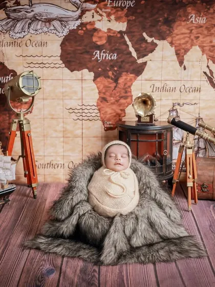 Our 'Little Traveler' theme, featuring a vintage world map, a telescope, and classic luggage. This setup is perfect for adventurous parents dreaming of future journeys with their baby.