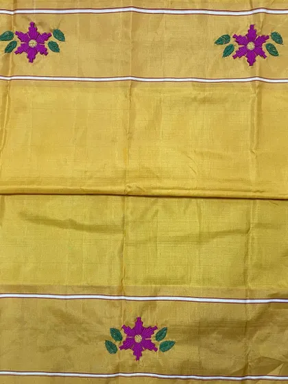 The body of the Kanjeevaram saree features scattered floral butis, hand-embroidered to match the intricate border. This technique adds a subtle richness to the entire length of the saree.