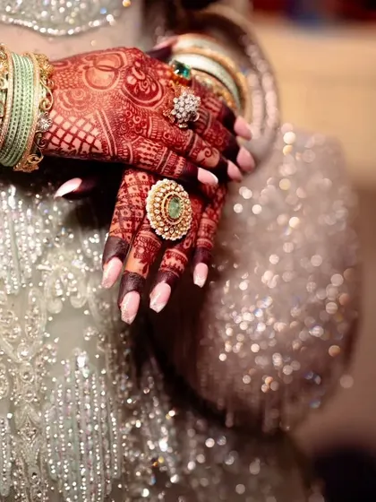 A close up of a beautiful, dark henna stain, adorned with stunning bridal jewelry. The color is rich and vibrant.
