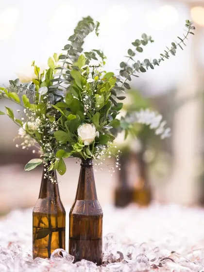 We believe in creative and sustainable decor. For this rustic Mehendi, we upcycled beer bottles into charming flower vases and used a boat as a unique centerpiece, all under a canopy of poetic string lights.
