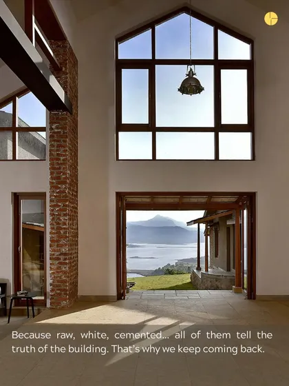 Raw, white, cemented... all of these materials tell the truth of the building. In this space, a large window frames a stunning natural view, while the exposed brick and white walls speak to the honesty of the construction.