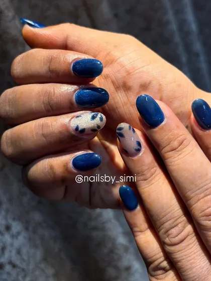 Nails you can’t stop staring at! This design shows the magic of cat-eye polish, with a deep blue base and accent nails featuring a cool, abstract pattern.