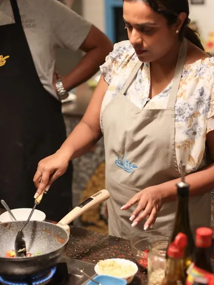 A student learns to manage the heat and stir-fry ingredients in a pan, gaining confidence in the kitchen with every dish.