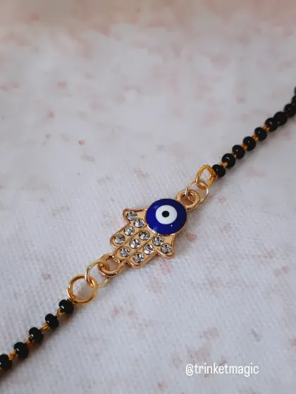 A close-up of the Hamsa hand evil eye charm. You can see the detailed stonework that adds a little sparkle to this protective bracelet.