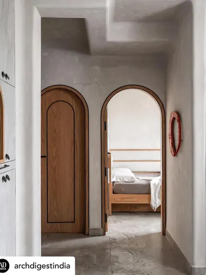 Arched doorways and softened edges are key to my Japandi-inspired designs. This view from the hallway into the bedroom of the 'Unmei' project shows how these elements create a gentle, flowing transition between spaces, enhancing the home's serene feel.