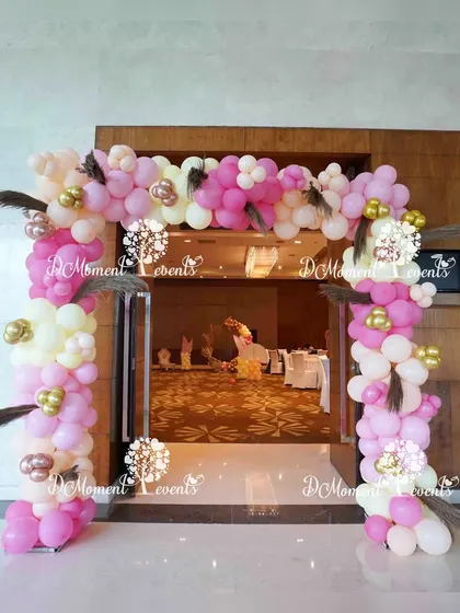 A pretty entrance arch for the Annaprashan ceremony, using pink and white balloons accented with feathers for a soft, delicate look.