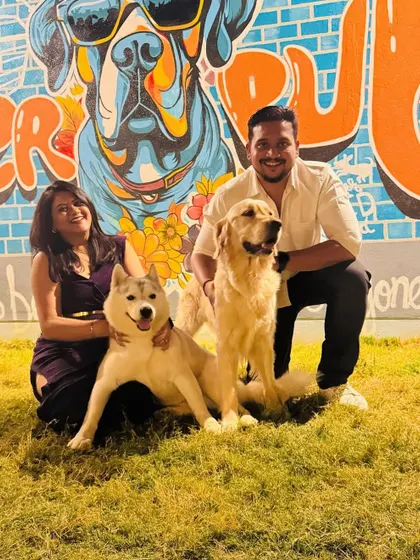 Our vibrant wall art makes for the perfect backdrop. Here, a happy couple poses with their husky and golden retriever, soaking in the fun atmosphere.