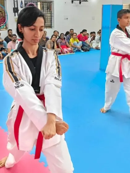 Two senior students demonstrate a form that includes kicks and blocks.