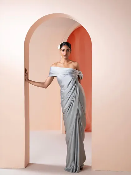A modern, pre-draped saree in a cool grey tone with an off-shoulder blouse. This is a perfect cocktail or reception outfit for a bride who wants comfort without sacrificing style.