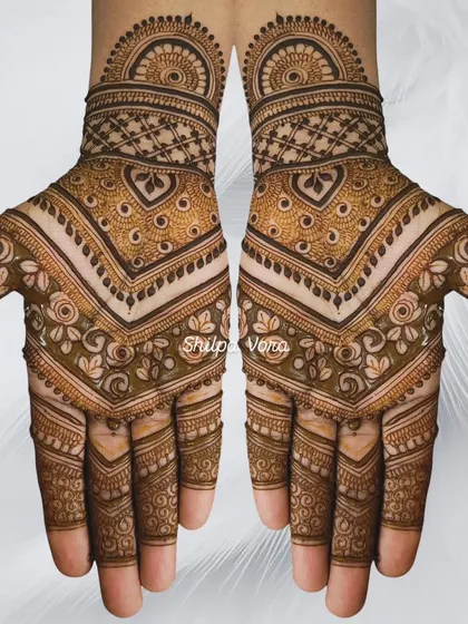 A symmetrical design with a V-shaped pattern on the palm, filled with delicate floral and leaf motifs.